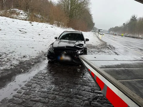 Mercedes mit Frontschaden auf dem Standstreifen der Autobahn im Winter