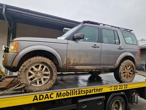 Gelände-Bergung: schlammverkrusteter Land Rover auf dem Abschleppwagen
