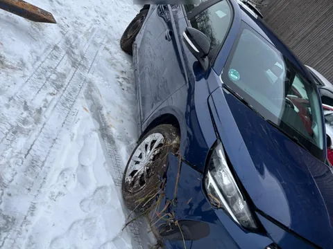 Blauer Opel mit abgerissenem Vorderrad und Seitenschaden im Schnee